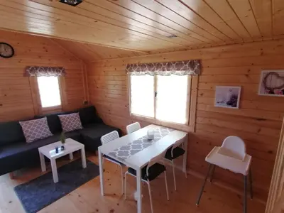 a living room with a table and a couch in a cabin at Nocleg Zator Domki Paradise Pod Palmami in Zator