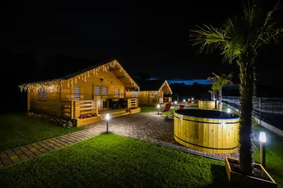 a house with a lit up yard at night at Nocleg Zator Domki Paradise Pod Palmami in Zator