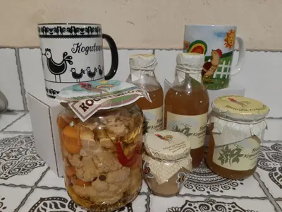 a table topped with jars of food and a mug at Kogutowo Agroturystyka MPR in Wietrzychowice