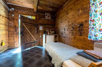 a bedroom with a bed and a wooden wall at Kogutowo Agroturystyka MPR in Wietrzychowice