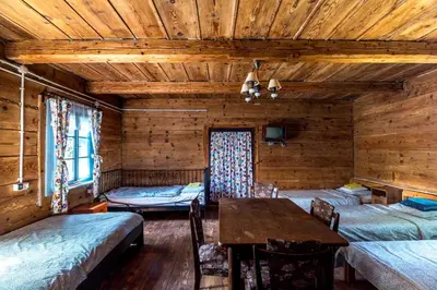 a room with three beds and a wooden ceiling at Kogutowo Agroturystyka MPR in Wietrzychowice