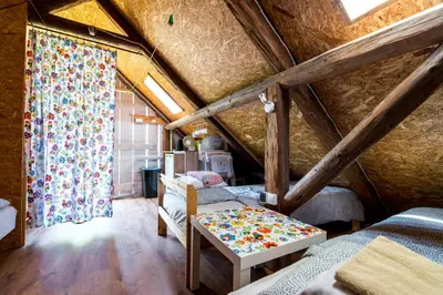 a room with a bed and a table in a attic at Kogutowo Agroturystyka MPR in Wietrzychowice