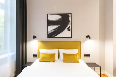 a bedroom with a bed with two yellow pillows at Nola Apartments in Kraków