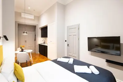a hotel room with two beds and a kitchen at Nola Apartments in Kraków