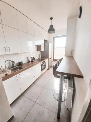 a kitchen with white cabinets and a sink at Apartament Kraków Arena No. 100 in Kraków
