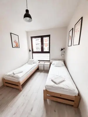 a room with two beds and a window at Apartament Kraków Arena No. 100 in Kraków