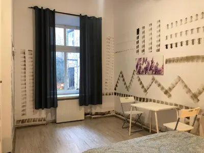 a bedroom with a window and a table and chairs at Pokój Sali 2 in Kraków