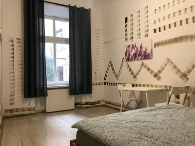 a bedroom with a bed and a desk and a window at Pokój Sali 2 in Kraków