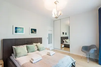 a bedroom with a bed and a mirror at Old Town Rakowicka by NEARTO in Kraków