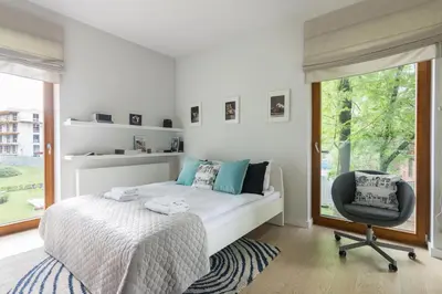 a bedroom with a bed and a chair and a window at Old Town Rakowicka by NEARTO in Kraków