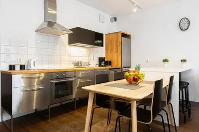a kitchen with a table with a bowl of fruit on it at Old Town Rakowicka by NEARTO in Kraków
