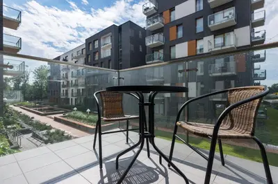 a table and two chairs on a balcony with a view at Old Town Rakowicka by NEARTO in Kraków