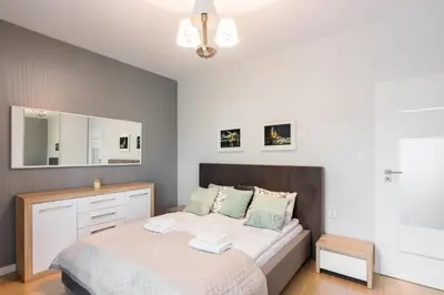 a bedroom with a bed with a dresser and a mirror at Old Town Rakowicka by NEARTO in Kraków