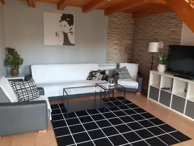 a living room with a white couch and a tv at Domek w górach in Sucha Beskidzka