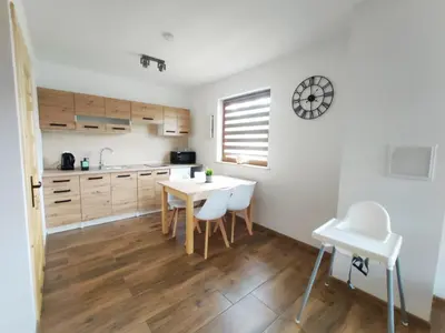 a kitchen with a table and chairs in a room at Happy Holiday domki Zator in Zator