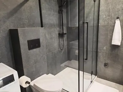 a bathroom with a shower and a toilet at Cracow by Night Apartments in Kraków