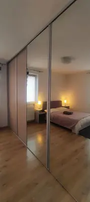 a small bedroom with a bed and two windows at Pleasant private and fully equipped apartment with private parking space close to District Kazimierz in Kraków