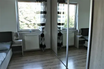 a room with a mirror and a couch and two windows at Pleasant private and fully equipped apartment with private parking space close to District Kazimierz in Kraków