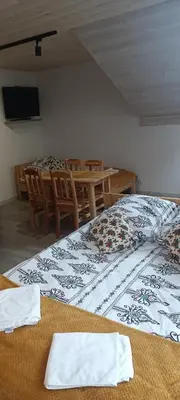 a room with a large bed with chairs and a table at Noclegi przy Skawie in Zator