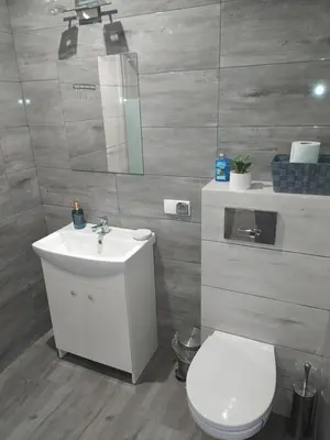 a bathroom with a white toilet and a sink at Noclegi przy Skawie in Zator