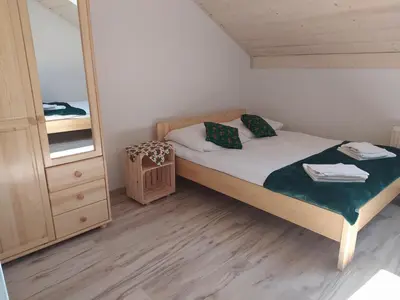 a small bedroom with a bed and a mirror at Noclegi przy Skawie in Zator
