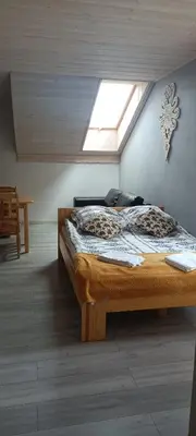 a bedroom with a bed in a attic with a window at Noclegi przy Skawie in Zator