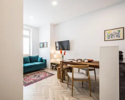 a living room with a table and a blue couch at NEW APARTMENT! Jewish quarter - SEGUNDO in Kraków
