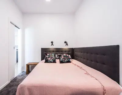 a bedroom with a large pink bed with pillows at NEW APARTMENT! Jewish quarter - SEGUNDO in Kraków