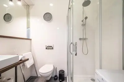 a white bathroom with a shower and a toilet at NEW APARTMENT! Jewish quarter - SEGUNDO in Kraków