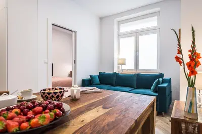 a living room with a blue couch and a table with fruit at NEW APARTMENT! Jewish quarter - SEGUNDO in Kraków