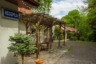 a wooden pergola sitting outside of a building at Noclegi Pod Dębem u Jakuba in Niepołomice