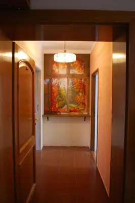 a hallway with a window and a painting on the wall at Villa For You in Oświęcim