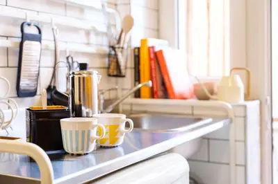 a kitchen counter with two coffee cups on it at Small folksy studio Kochanowskiego St in Kraków