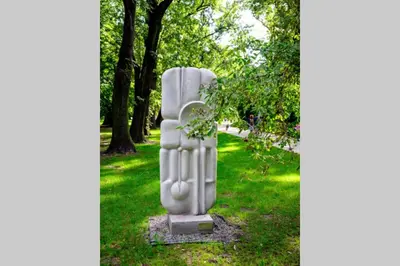 a statue in the grass in a park at Small folksy studio Kochanowskiego St in Kraków