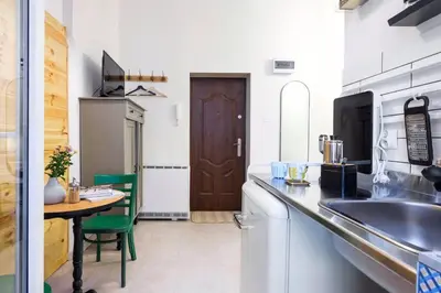 a kitchen with a table and a sink and a counter top at Small folksy studio Kochanowskiego St in Kraków