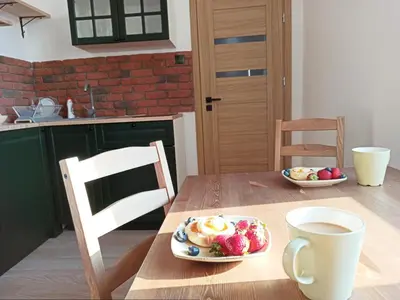 a table with a plate of fruit and a cup of coffee at Wieliczka City Apartments in Wieliczka