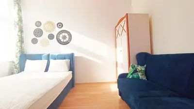a bedroom with a bed and a blue couch at Wieliczka City Apartments in Wieliczka