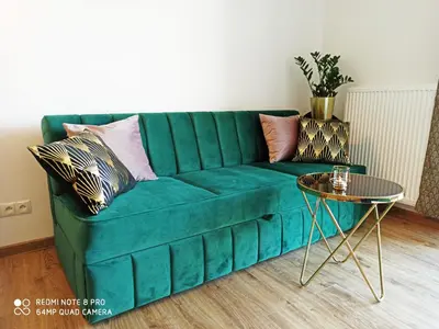 a green couch in a living room with a table at Wieliczka City Apartments in Wieliczka