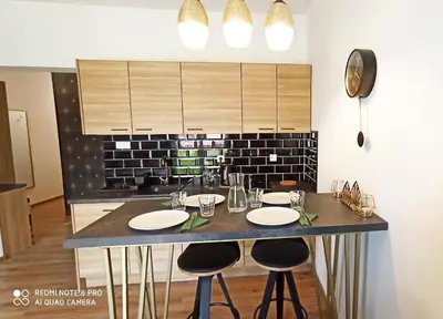 a kitchen with a counter with stools and a sink at Wieliczka City Apartments in Wieliczka