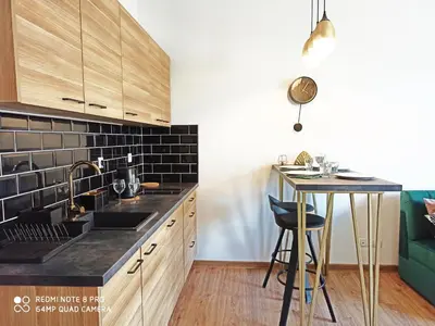 a kitchen with a sink and a counter with a table at Wieliczka City Apartments in Wieliczka