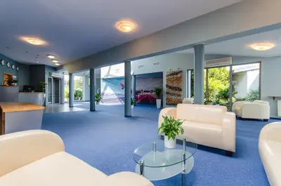 a living room with white furniture and a table at HOTEL A4 Airport Kraków MOP Morawica in Aleksandrowice