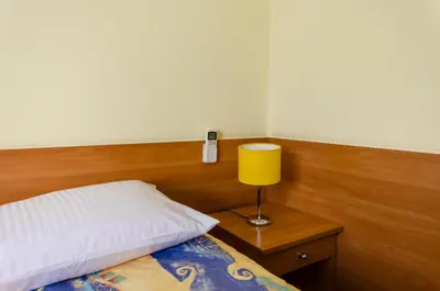 a bedroom with a bed with a lamp and a phone at HOTEL A4 Airport Kraków MOP Morawica in Aleksandrowice