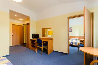 a hotel room with a bed and a desk with a computer at HOTEL A4 Airport Kraków MOP Morawica in Aleksandrowice