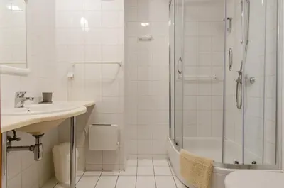 a white bathroom with a shower and a sink at HOTEL A4 Airport Kraków MOP Morawica in Aleksandrowice