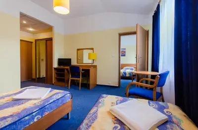 a hotel room with two beds and a desk at HOTEL A4 Airport Kraków MOP Morawica in Aleksandrowice