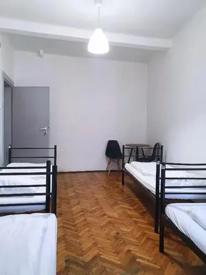 a room with three bunk beds and a wooden floor at VIKI Kazimierz in Kraków