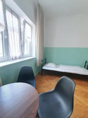 a room with a table and chairs and two beds at VIKI Kazimierz in Kraków