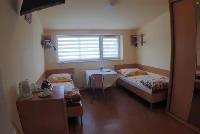 a room with two beds and a table and a window at Nawojka Hotele Studenckie in Kraków