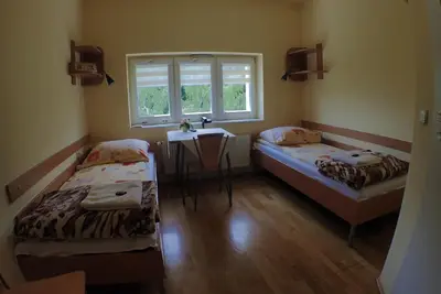 two beds in a room with a table and a window at Nawojka Hotele Studenckie in Kraków