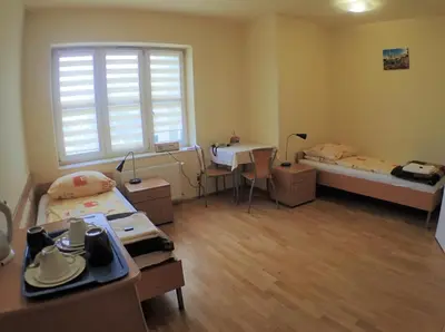 a room with two beds and a table and a window at Nawojka Hotele Studenckie in Kraków